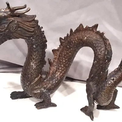 Vintage cast bronze Asian dragon sculpture, featuring detailed scales, a serpentine body, and a dark, aged patina.