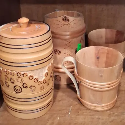 Vintage hand-carved wooden canister set and matching mugs featuring pyrography details and traditional folk art designs.