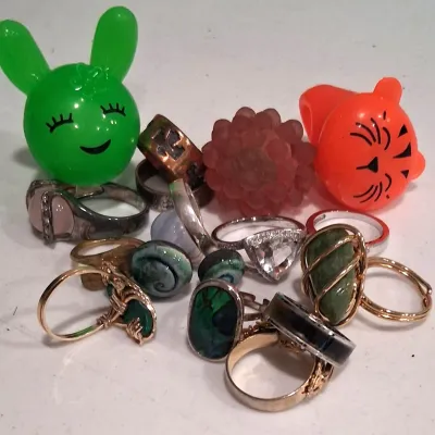 Assortment of vintage and novelty rings, including wire-wrapped gemstone rings, a triangular rhinestone ring, and colorful plastic...