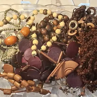 Assortment of bohemian and natural-style costume jewelry, featuring wooden, seed, and beaded necklaces and bracelets in earthy tones,...