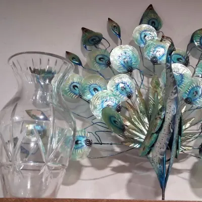 Vintage Fenton milk glass hand-painted floral vase, a cut crystal vase, and a decorative metal and capiz shell peacock sculpture.