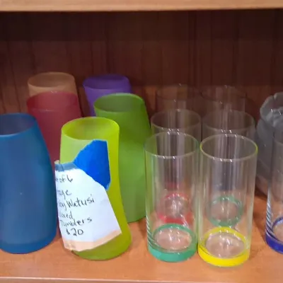 Vintage Libbey Watusi colored tumblers in frosted blue, green, and pink, alongside clear highball glasses with colorful bases and a clear...