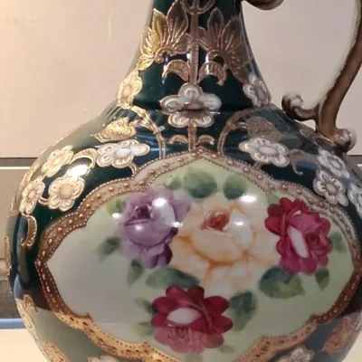 Vintage hand-painted porcelain ewer featuring a dark green glaze, ornate gold moriage detailing, and a central floral cartouche with...
