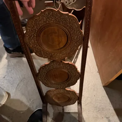 Sale Photo Thumbnail #243: Vintage Anglo-Indian carved wood folding cake stand, featuring three tiers with intricate floral relief carvings and a turned carrying handle.