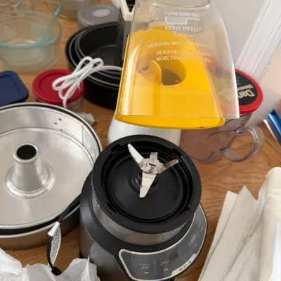 Ninja Auto-iQ blender base with blade assembly, shown alongside a vintage hot air popcorn popper and various baking pans.