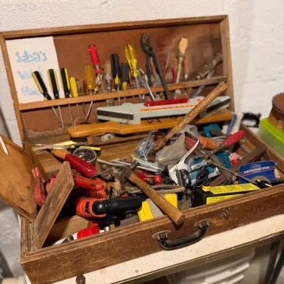 Sale Photo Thumbnail #173: Vintage wooden tool chest filled with an assortment of hand tools, including screwdrivers, hammers, and pliers.
