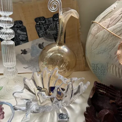 Assorted vintage collectibles including a clear glass candlestick, an amber glass cruet with a scrolled handle, a ruffled glass dish...
