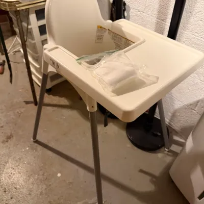 Sale Photo Thumbnail #238: IKEA Antilop high chair with a white plastic seat and tray, supported by silver-colored metal legs.