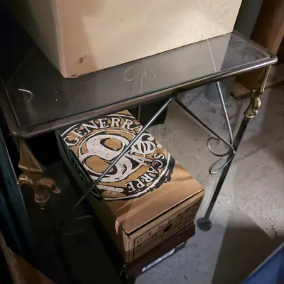 Sale Photo Thumbnail #246: Vintage Generra Scarpe shoe box stored beneath a metal and glass console table with fleur-de-lis accents.