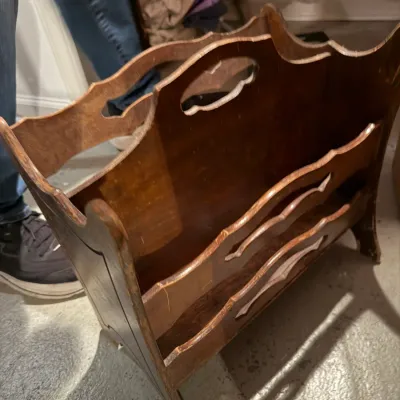 Sale Photo Thumbnail #242: Vintage wooden magazine rack with a central carrying handle, scalloped edges, and cutout details, showing some surface wear.