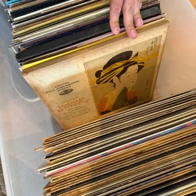 Collection of vintage vinyl records stored in a plastic bin, featuring a Capitol Records box set of Puccini's Madame Butterfly.