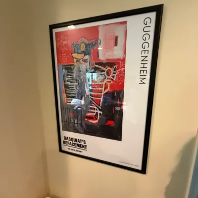 Framed exhibition poster for "Basquiat's 'Defacement': The Untold Story" at the Guggenheim Museum, featuring...
