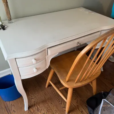 Sale Photo Thumbnail #146: White painted wooden writing desk with cabriole legs and multiple drawers, paired with a natural wood Windsor-style chair.