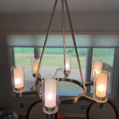 Modern five-light chandelier featuring a brushed nickel finish and cylindrical double-glass shades with frosted inner sleeves.