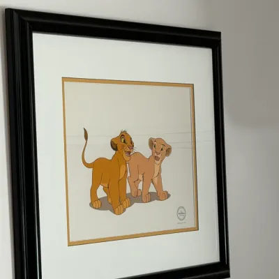 Sale Photo Thumbnail #134: Framed Disney animation cel featuring young Simba and Nala from The Lion King, complete with a Walt Disney Company seal of authenticity.