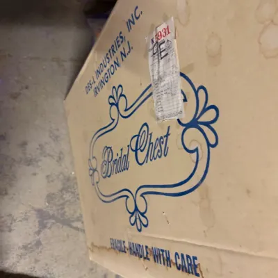 Sale Photo Thumbnail #216: Vintage cardboard storage box labeled "Bridal Chest" from Des-L Industries, Inc., showing significant water staining and wear.