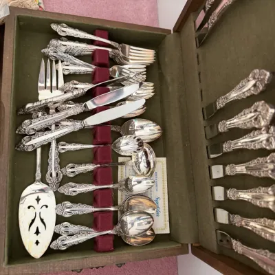 Sale Photo Thumbnail #108: Reed & Barton silver-plated flatware set in an ornate floral pattern, presented in a green felt-lined wooden storage chest.