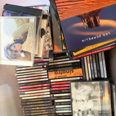 A collection of music CDs and DVDs, featuring artists such as Led Zeppelin, Frank Sinatra, and Kelly Clarkson.