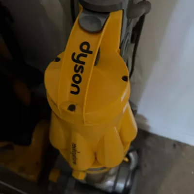 Sale Photo Thumbnail #211: Dyson Root Cyclone upright vacuum cleaner in yellow and grey, showing some signs of use.