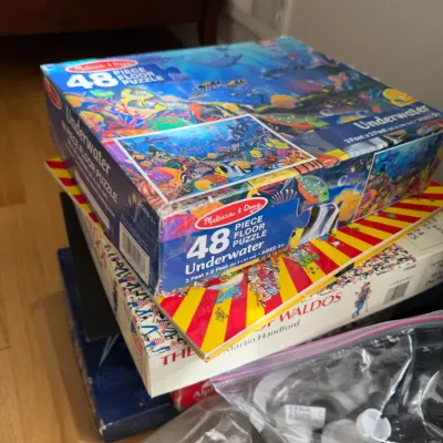 Melissa & Doug 48-piece underwater floor puzzle, stacked on top of a Where's Waldo book and other games.
