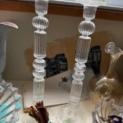 Pair of vintage clear glass candlesticks featuring ribbed and beaded stacked column designs with flared tops and swirled bases.