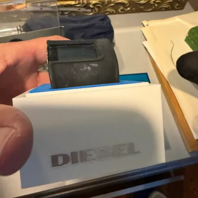 Sale Photo Thumbnail #158: Diesel digital watch with a black rubber strap, presented in its original white and blue branded display box.