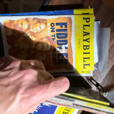 A collection of vintage theater playbills, featuring a prominent Playbill for "Fiddler on the Roof in Yiddish" at Stage 42.