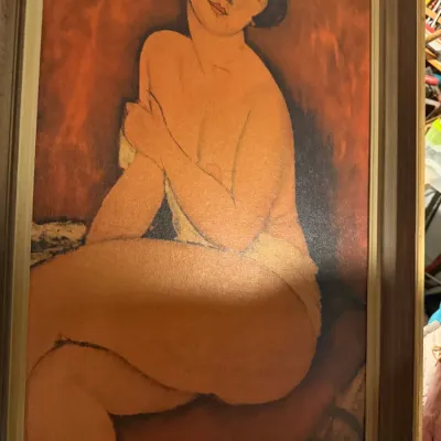 Sale Photo Thumbnail #196: Framed reproduction print of Amedeo Modigliani's "La Belle Romaine" (The Beautiful Roman Woman), featuring a seated female nude against a warm red background.