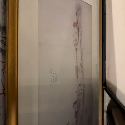 Sale Photo Thumbnail #231: Framed watercolor print depicting a minimalist landscape with red-roofed buildings, housed in a gold-finished frame with a wide white mat.