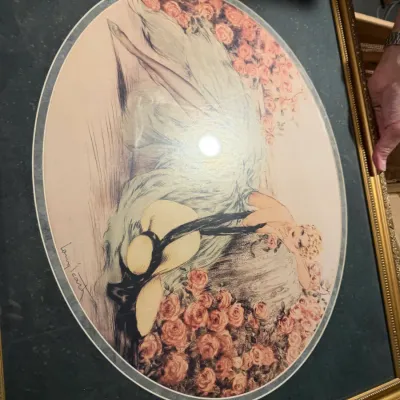 Sale Photo Thumbnail #189: Framed Louis Icart print titled "La Dame aux Camelias," featuring an oval matting and an ornate gold-finished frame.