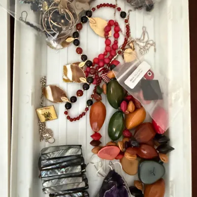 Assortment of vintage costume jewelry, including beaded necklaces, a mother-of-pearl stretch bracelet, and various loose beads and charms...