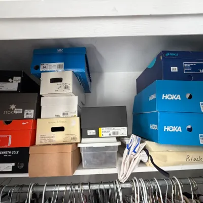 Sale Photo Thumbnail #145: Assorted shoe boxes on a closet shelf, including brands like Hoka, Nike, Adidas, Asics, and Kenneth Cole.