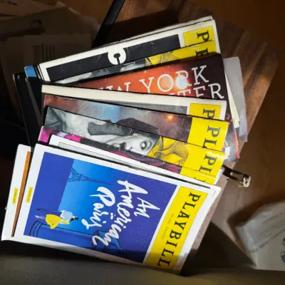 A collection of vintage and modern Broadway Playbills, including "An American in Paris" from the Palace Theatre, showing some...