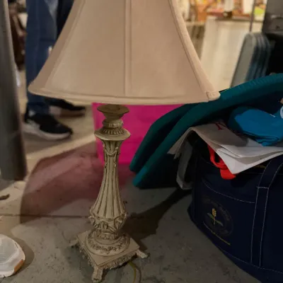 Sale Photo Thumbnail #168: Vintage-style table lamp featuring an ornate, off-white composite base with classical fluting and scrollwork, paired with a matching bell-shaped fabric shade.