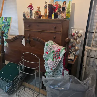 Antique wooden dresser and matching headboard, shown with various holiday decorations, a metal stand, and cushions.