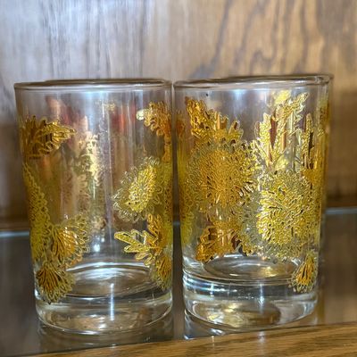 Sale Photo Thumbnail #77: A beautiful set of eight (8) vintage lowball tumbler glasses featuring a textured 22-karat yellow gold chrysanthemum floral and leaf pattern. Likely produced by Culver Ltd. in their iconic mid-century style. Each glass features a thick, weighted base and 