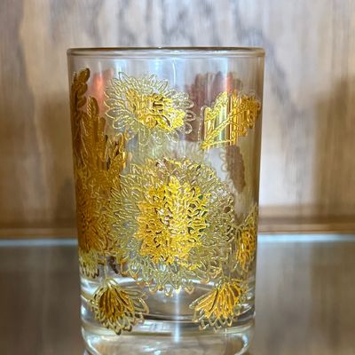 Sale Photo Thumbnail #76: A beautiful set of eight (8) vintage lowball tumbler glasses featuring a textured 22-karat yellow gold chrysanthemum floral and leaf pattern. Likely produced by Culver Ltd. in their iconic mid-century style. Each glass features a thick, weighted base and 