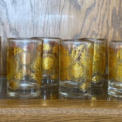 Sale Photo Thumbnail #75: A beautiful set of eight (8) vintage lowball tumbler glasses featuring a textured 22-karat yellow gold chrysanthemum floral and leaf pattern. Likely produced by Culver Ltd. in their iconic mid-century style. Each glass features a thick, weighted base and 