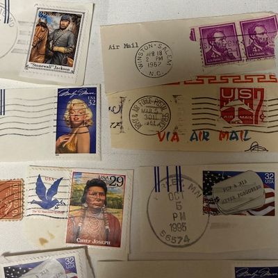 Sale Photo Thumbnail #99: A collection of vintage United States postage stamps on paper clippings, featuring various postmarks from the 1960s and 1990s. The lot includes notable stamps such as the 32¢ Marilyn Monroe, 29¢ Chief Joseph, 32¢ "Stonewall" Jackson, 20¢ American Clip