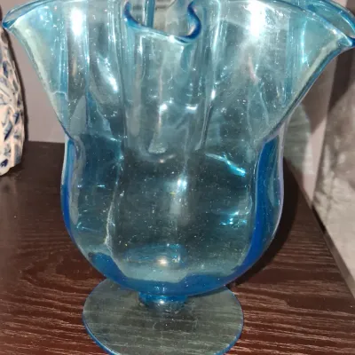 Sale Photo Thumbnail #125: Vintage hand-blown blue glass vase featuring a ruffled rim and a pedestal base.