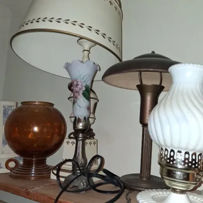 Sale Photo Thumbnail #43: Assortment of vintage table lamps, including a hand-painted floral glass lamp with a patterned shade, a bronze-finish mushroom lamp, and a white milk glass hurricane lamp.