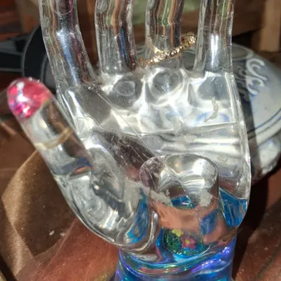 Sale Photo Thumbnail #33: Vintage clear acrylic hand-shaped jewelry display stand featuring painted pink fingernails and a blue base with embedded floral details.