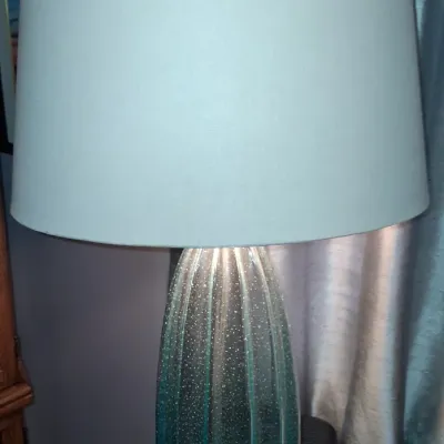 Sale Photo Thumbnail #145: Contemporary table lamp featuring a ribbed, aqua-blue seeded glass base and a matching light blue drum shade.