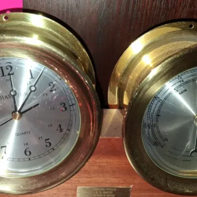 Sale Photo Thumbnail #114: Vintage Hampton brass quartz ship's clock and matching barometer set, mounted on a wooden base with a presentation plaque.