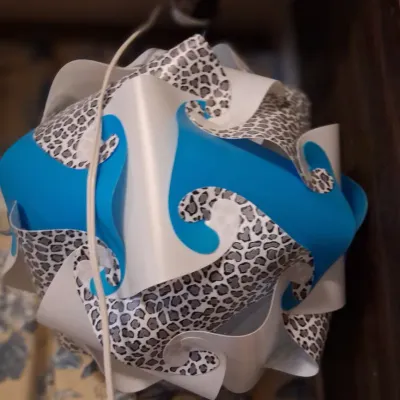 Sale Photo Thumbnail #80: Contemporary puzzle lamp shade featuring interlocking plastic pieces in solid blue, white, and a grey leopard print pattern.