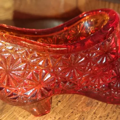Sale Photo Thumbnail #138: Vintage Fenton amberina glass shoe figurine featuring a daisy and button pattern, showing a vibrant red-to-orange gradient.