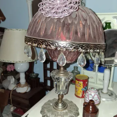 Sale Photo Thumbnail #55: Vintage Hollywood Regency style table lamp featuring a pink glass shade with hanging crystal prisms and a clear glass base.