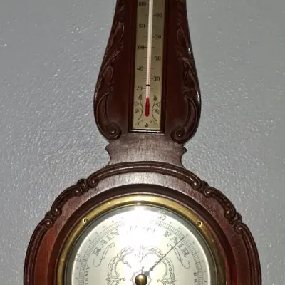 Sale Photo Thumbnail #57: Vintage Airguide banjo-style wall barometer with integrated thermometer and hygrometer, housed in a dark-stained wooden case with traditional scrollwork details.