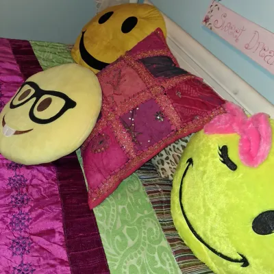 Sale Photo Thumbnail #37: Assortment of novelty throw pillows, including three plush emoji-style smiley faces and a pink patchwork decorative pillow with sequin details.