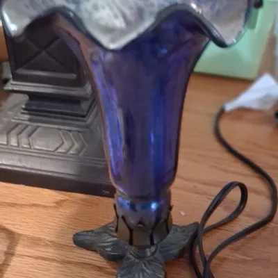 Sale Photo Thumbnail #107: Vintage tulip-style accent lamp featuring a ruffled cobalt blue glass shade on a decorative cast metal base.